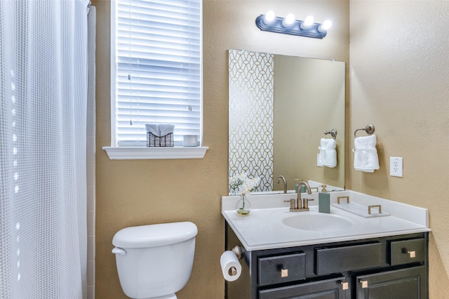 bathroom featuring vanity, toilet, and walk in shower