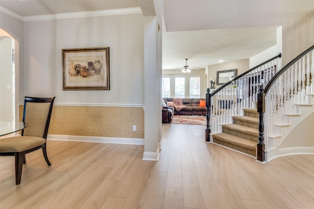 entrance foyer with crown molding, ceiling fan, and light wood-type flooring