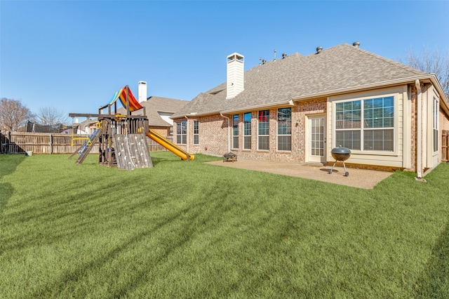 rear view of property featuring a yard, a patio area, and a playground