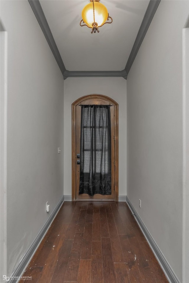 foyer entrance featuring ornamental molding and dark wood-type flooring