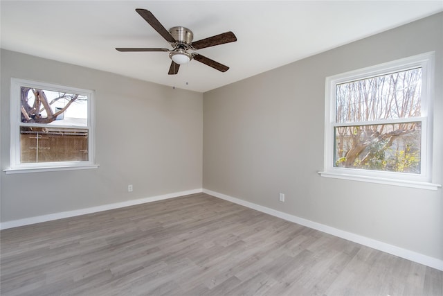 unfurnished room featuring plenty of natural light, ceiling fan, and light wood-type flooring