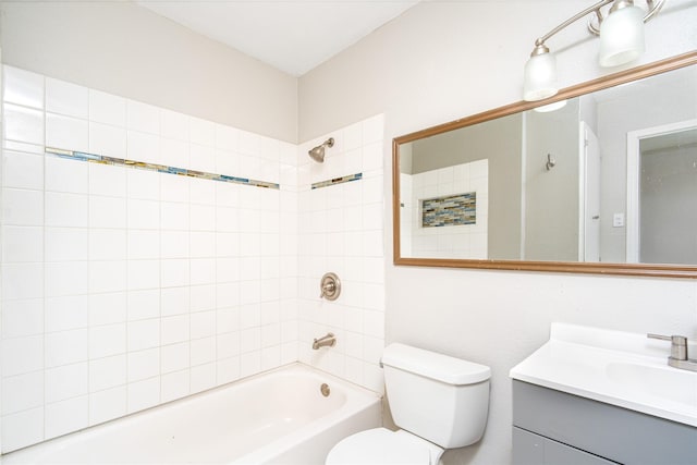 full bathroom featuring tiled shower / bath, vanity, and toilet