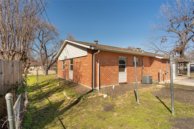 view of property exterior with central AC and a lawn