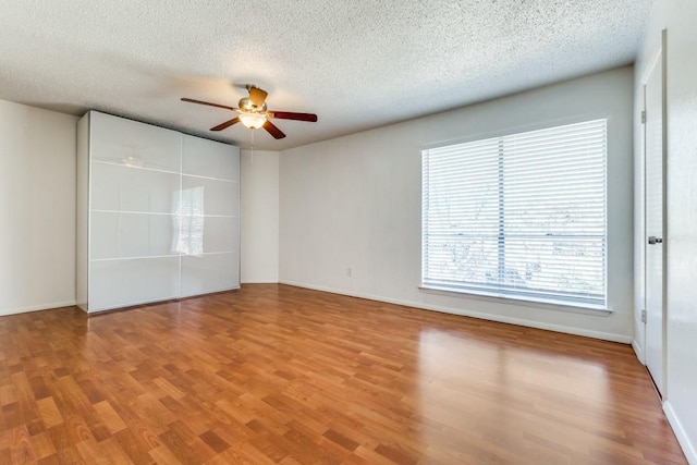 empty room featuring hardwood / wood-style floors, a textured ceiling, and ceiling fan