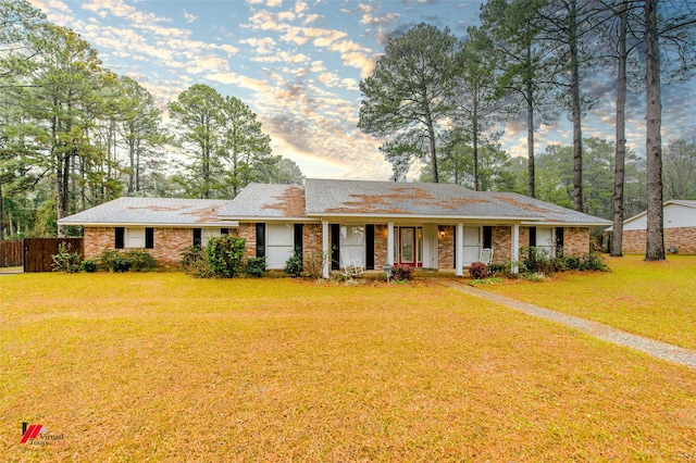 ranch-style house with a yard and covered porch