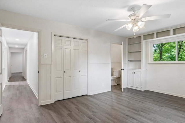 unfurnished bedroom with ensuite bathroom, dark hardwood / wood-style floors, ceiling fan, and a closet