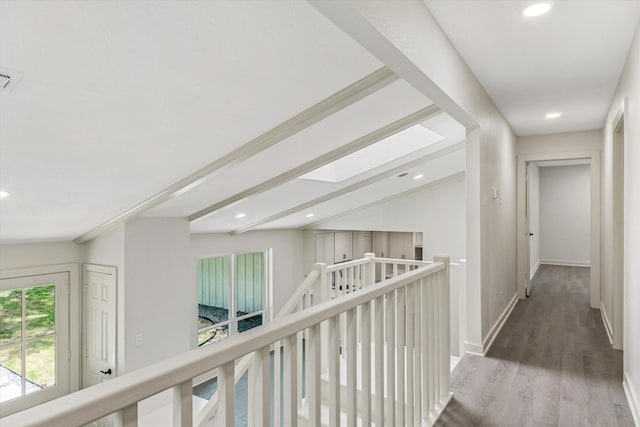 hallway with hardwood / wood-style floors and lofted ceiling with skylight