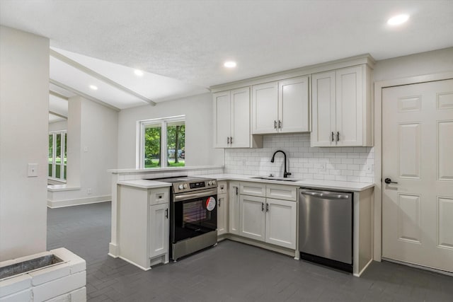 kitchen featuring tasteful backsplash, white cabinetry, sink, kitchen peninsula, and stainless steel appliances