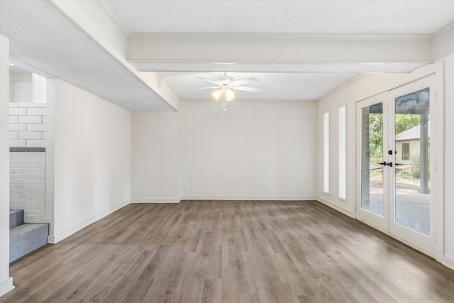 empty room with crown molding, a textured ceiling, and light wood-type flooring