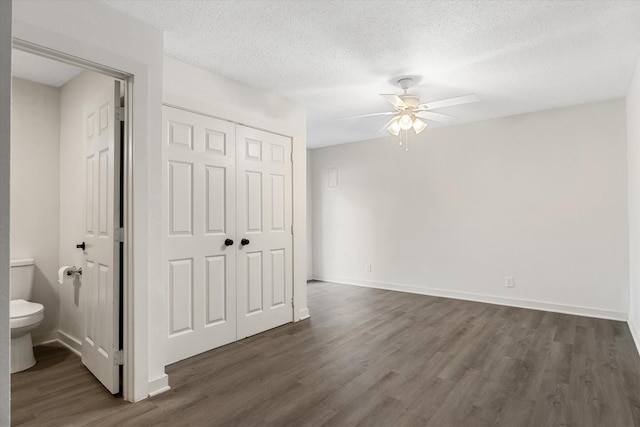 interior space featuring ceiling fan, dark wood-type flooring, and a textured ceiling