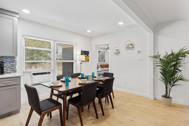 dining area with cooling unit and light wood-type flooring