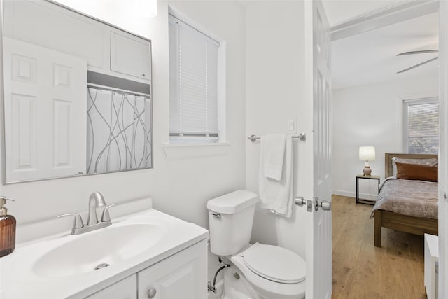 bathroom with hardwood / wood-style flooring, ceiling fan, vanity, and toilet