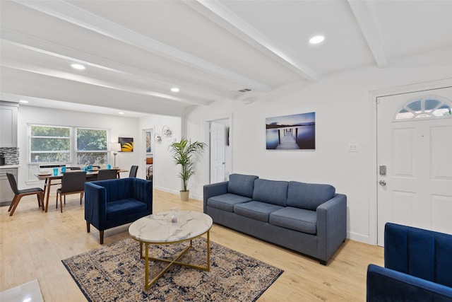 living room with beamed ceiling and light wood-type flooring