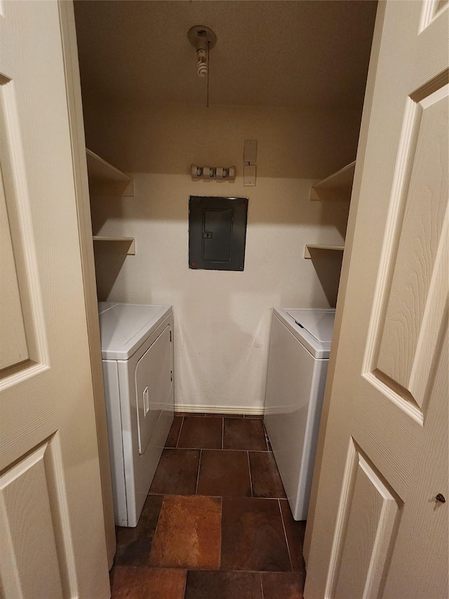 laundry area featuring washing machine and dryer, electric panel, and dark tile patterned flooring