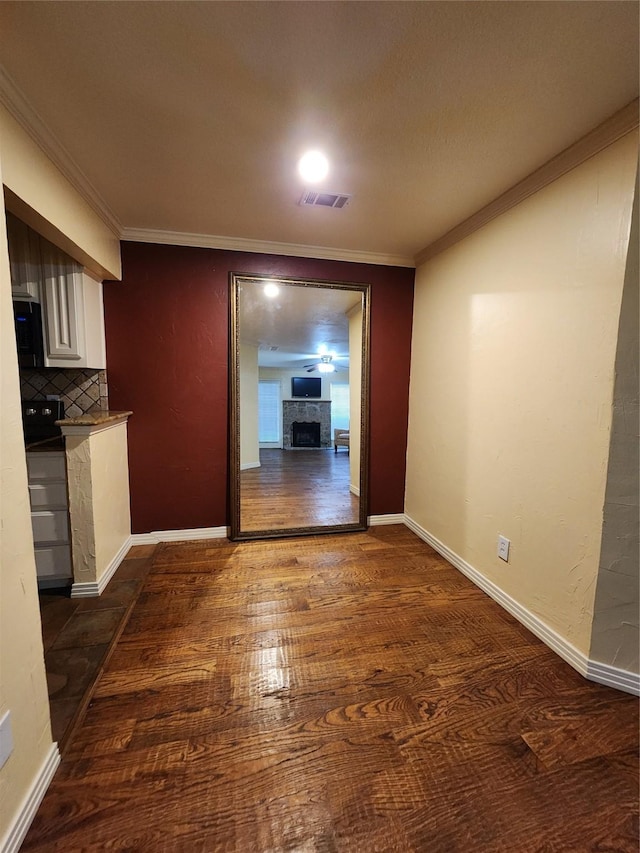 unfurnished dining area featuring crown molding and dark wood-type flooring