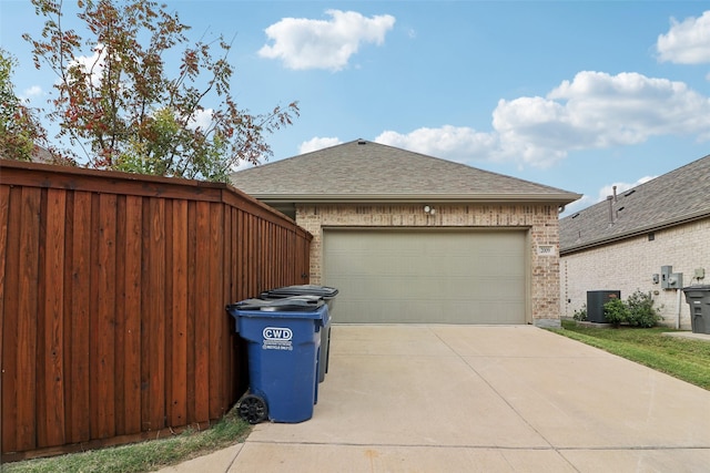 view of side of property with a garage and central air condition unit