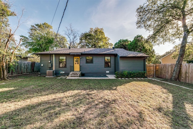 view of front of home featuring cooling unit, a front lawn, and a patio