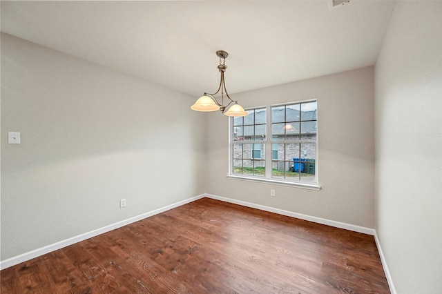 spare room with dark wood-style flooring and baseboards