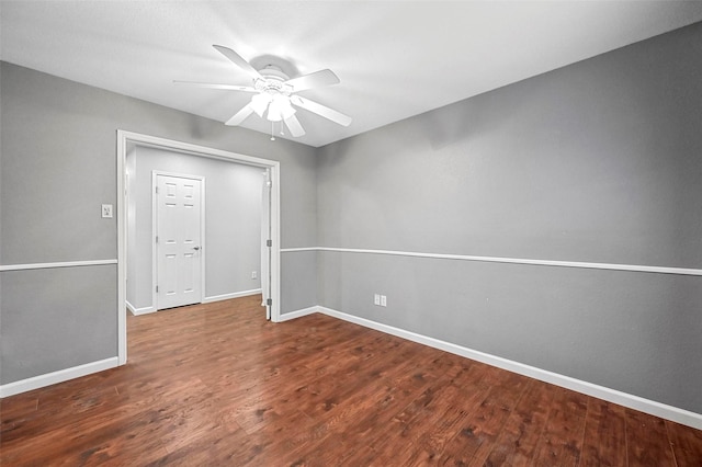 empty room with a ceiling fan, baseboards, and wood finished floors