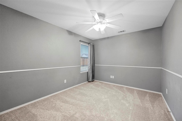 empty room featuring ceiling fan, carpet flooring, visible vents, and baseboards