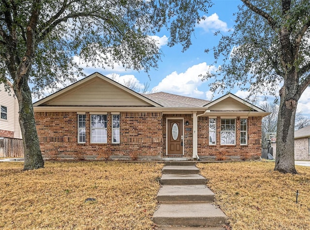 single story home featuring brick siding and a front lawn