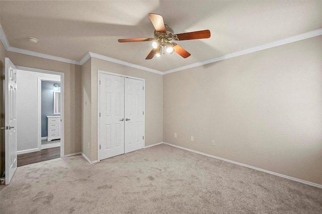 unfurnished bedroom with carpet, crown molding, a closet, a ceiling fan, and baseboards