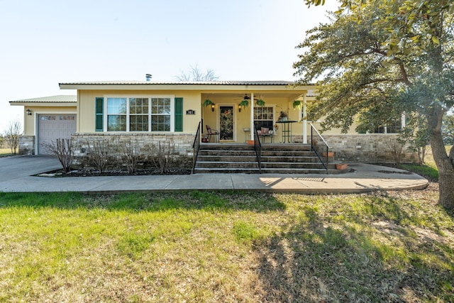view of front facade with a garage, a porch, and a front yard