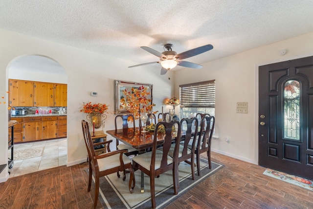 dining room featuring a textured ceiling, wood-type flooring, and ceiling fan