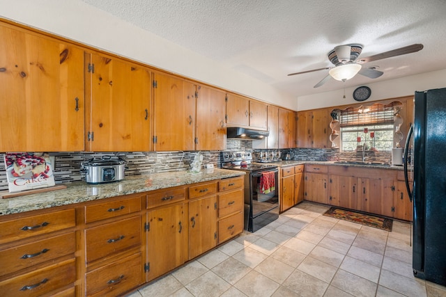 kitchen featuring sink, black appliances, ceiling fan, light stone countertops, and backsplash