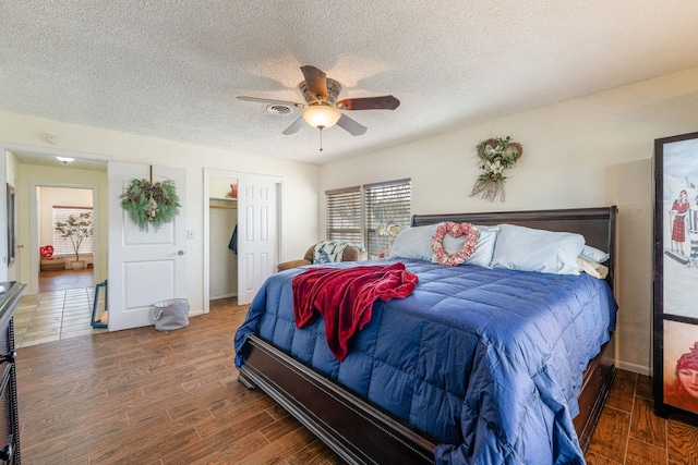 bedroom featuring dark hardwood / wood-style flooring, a textured ceiling, a closet, and ceiling fan