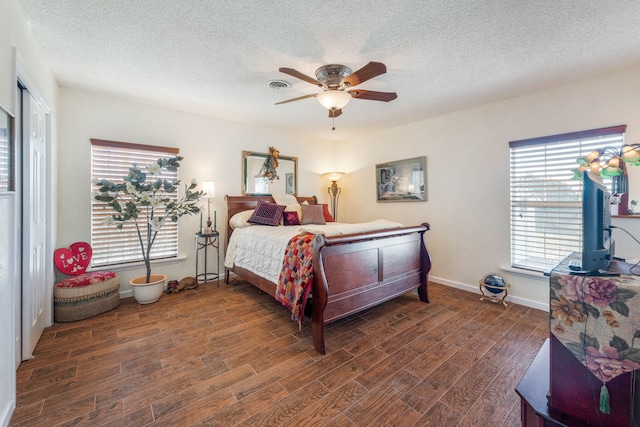 bedroom with ceiling fan, dark wood-type flooring, and a textured ceiling