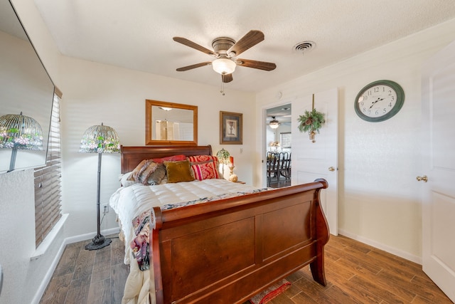 bedroom featuring ceiling fan, a textured ceiling, and dark hardwood / wood-style flooring