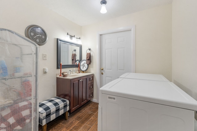 clothes washing area featuring washing machine and dryer, sink, and a textured ceiling