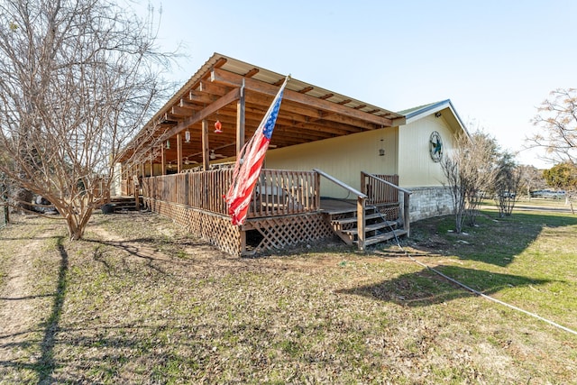 back of house featuring a wooden deck and a lawn