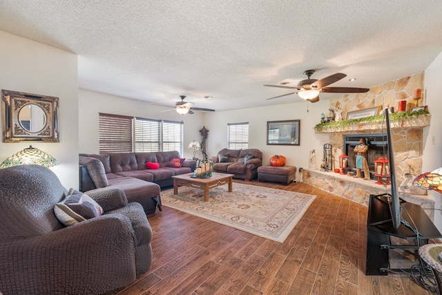 living room featuring ceiling fan, dark hardwood / wood-style flooring, and a textured ceiling