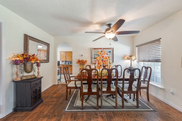 dining area featuring dark wood-type flooring, ceiling fan, and a textured ceiling