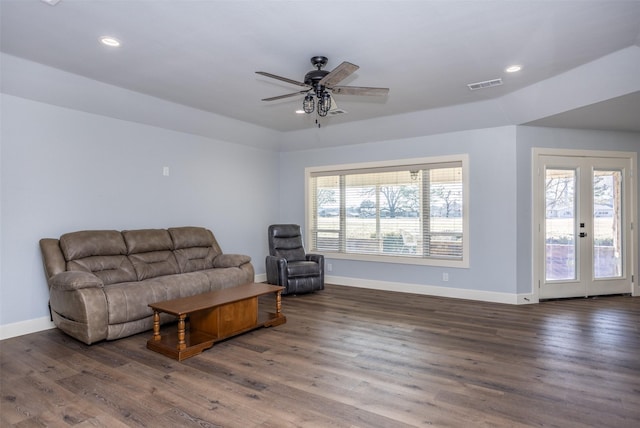 living room with dark wood-type flooring, plenty of natural light, and french doors