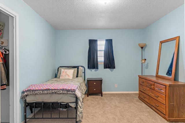 bedroom with light carpet and a textured ceiling