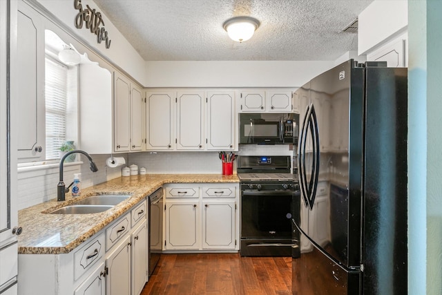 kitchen featuring sink, dark wood-type flooring, white cabinetry, tasteful backsplash, and black appliances