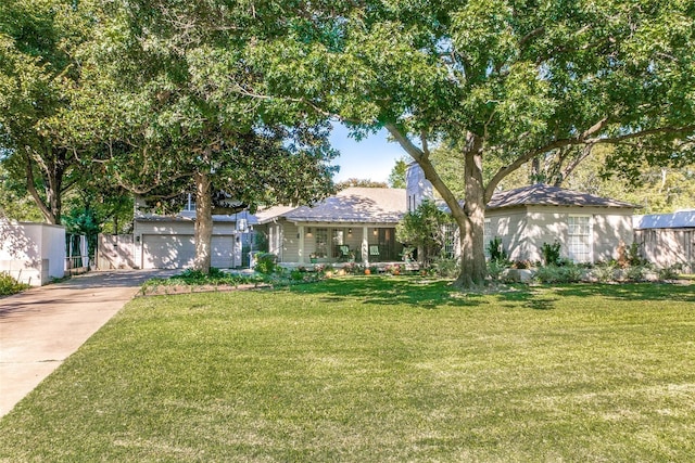 view of front of property featuring a garage, a front lawn, and covered porch