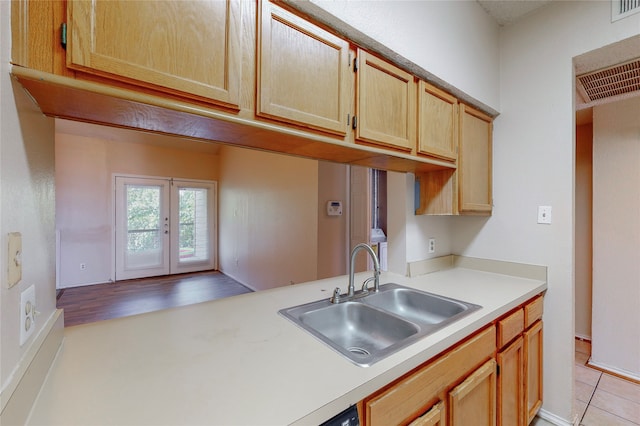 kitchen featuring sink, light tile patterned floors, and french doors