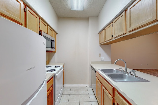 kitchen with sink, light tile patterned floors, stainless steel appliances, and a textured ceiling