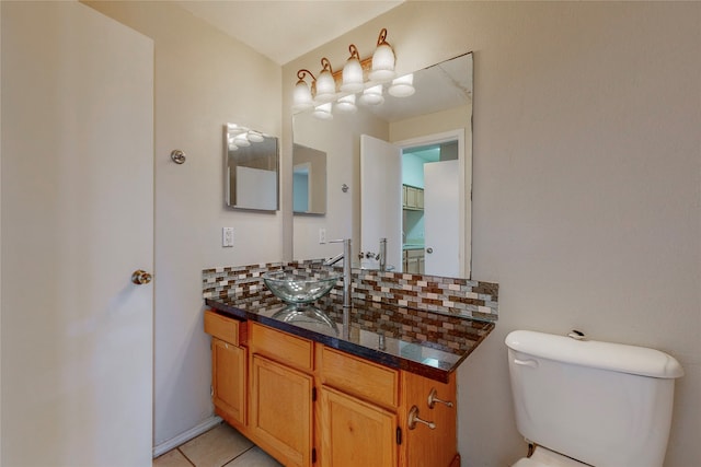 bathroom featuring vanity, tile patterned flooring, decorative backsplash, and toilet