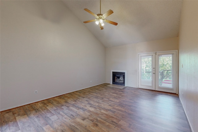 unfurnished living room with ceiling fan, hardwood / wood-style floors, high vaulted ceiling, a textured ceiling, and french doors