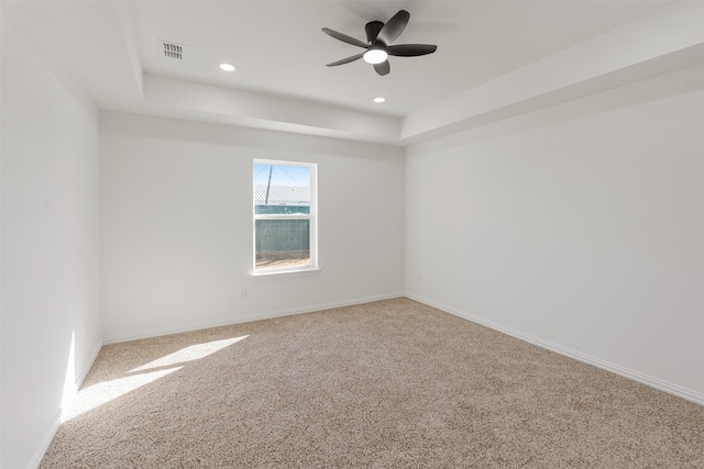 carpeted spare room with a ceiling fan, visible vents, baseboards, recessed lighting, and a raised ceiling