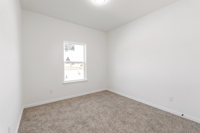 carpeted empty room with baseboards