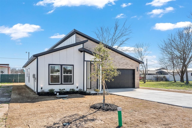 view of front facade featuring driveway, fence, board and batten siding, an attached garage, and brick siding