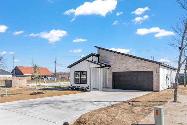 view of front of property with concrete driveway, a garage, and brick siding