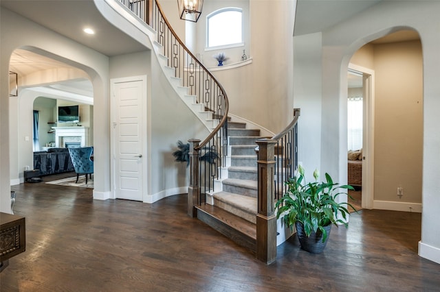 stairs featuring hardwood / wood-style flooring and a towering ceiling