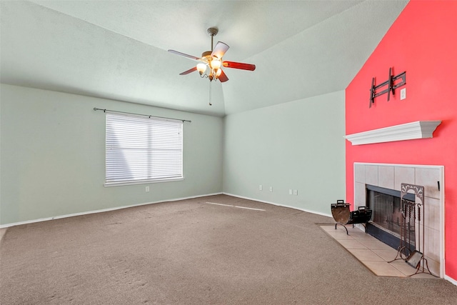 unfurnished living room with ceiling fan, lofted ceiling, a tiled fireplace, and light carpet